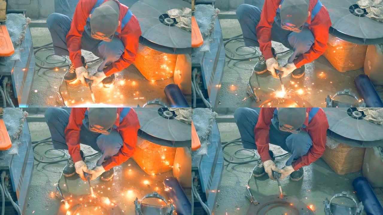 一位年长的男性铁匠在没有眼镜的情况下工作，用焊接机焊接金属零件。