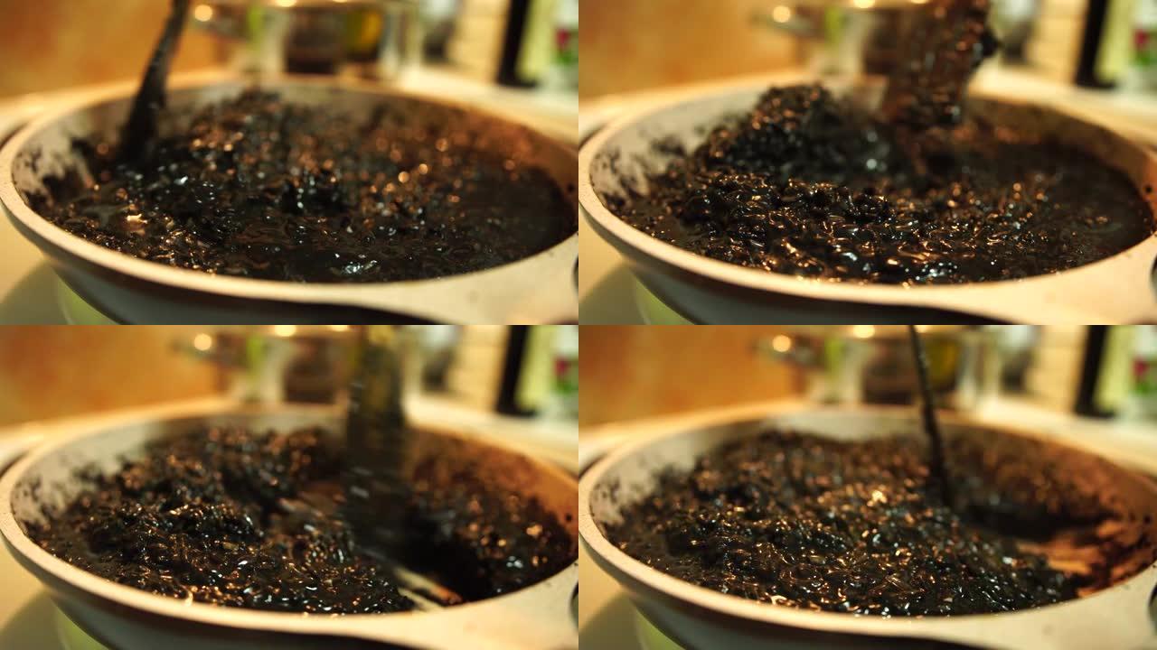 用锅铲在锅里搅拌黑色意大利调味饭。煮米饭做黑烩饭。