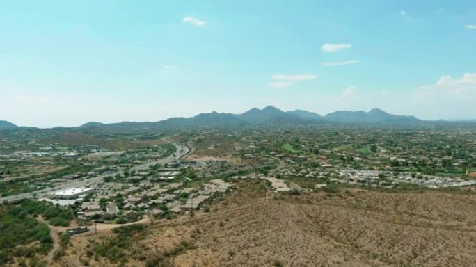 在美国亚利桑那州阳光明媚的日子里，一架无人机在山沙漠附近的小喷泉山镇的一座低矮房屋上飞行
