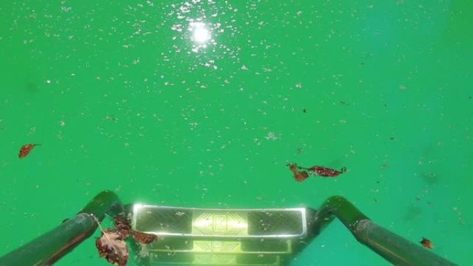 带金属扶手和台阶的游泳池入口。池水开始从没有化学反应的细菌和藻类变成绿色。水净化是必要的氯片。视频。