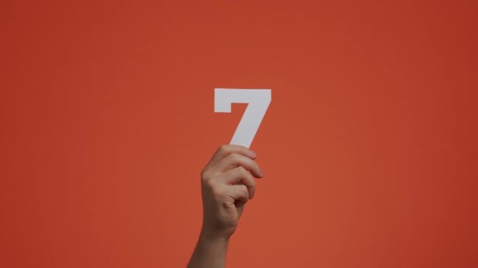 手中的第七名。手臂显示数字，第七个数字由雕刻纸制成，用于投票或学习
