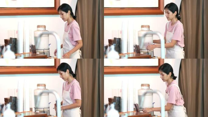 4k年轻亚洲女服务员开门前打扫咖啡店。