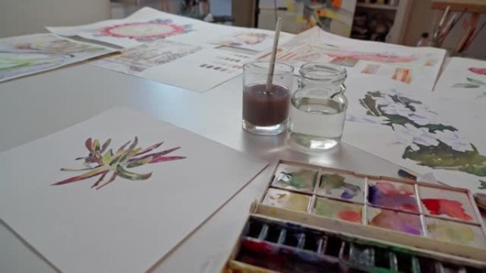 艺术工作室。桌子上的图纸是用水彩画制成的。慢动作。特写。