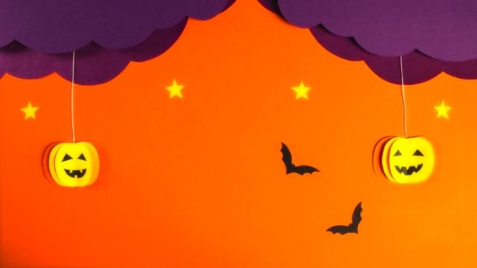 两个南瓜从卷曲的丁香云中掉下来。星星点亮，黑色蝙蝠飞翔。万圣节庆祝概念。停止运动动画。