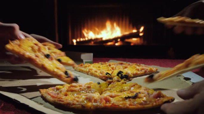 一群人一块一块地吃美味的披萨，在壁炉旁吃晚餐