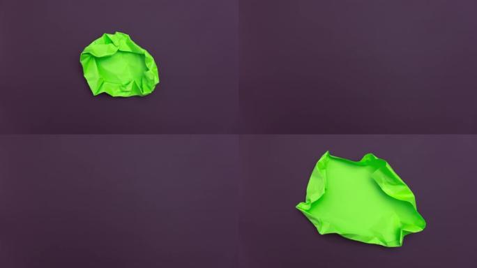 停止运动动画 _ 深紫色背景上的绿色纸球展开 _ 绿色屏幕