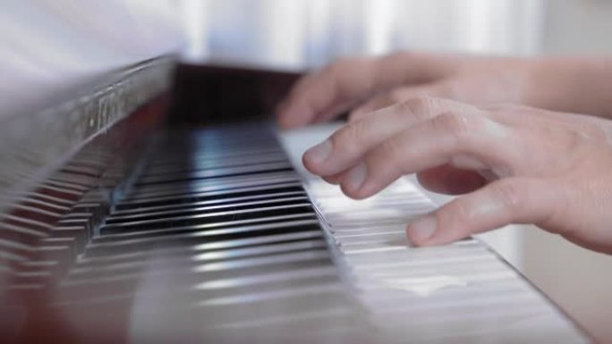 弹钢琴的人的灵巧手，特写，侧视图。教或学演奏乐器。爱好和娱乐的概念。