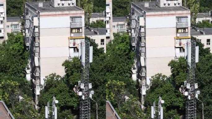 建筑工人挂在4g塔架结构上，休息时吸烟