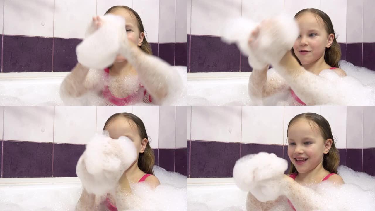 漂亮的女孩穿着粉红色的泳衣，浴缸里有很多泡沫。她玩着手上的泡沫。