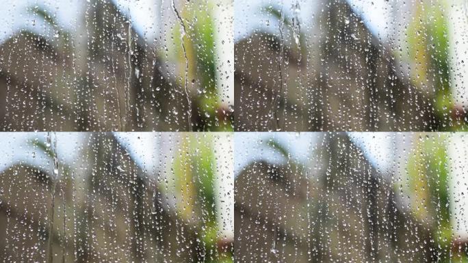 雨水落下，雨水落在透明玻璃上，水慢慢流过透明玻璃。