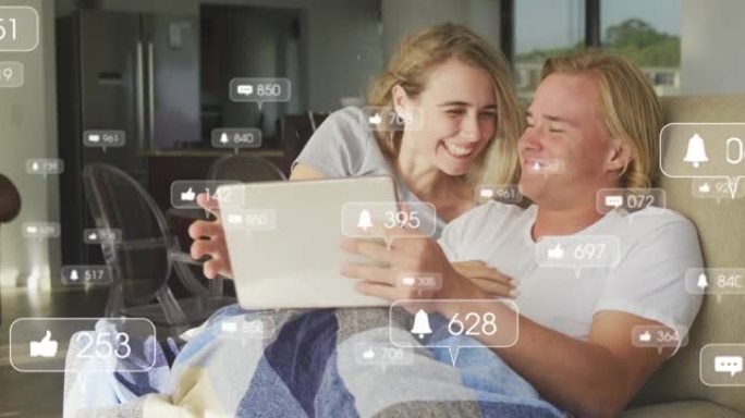 使用平板电脑和在家拥抱幸福夫妇的社交媒体图标动画