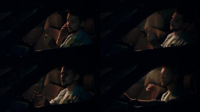 男人晚上坐在车里，抽烟，打电话。