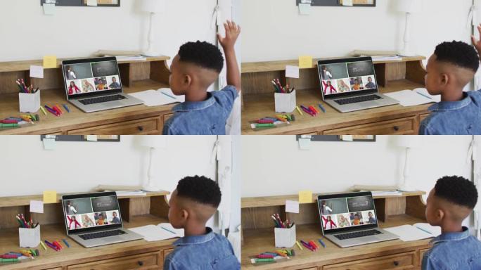 非裔美国男孩在家里用笔记本电脑进行视频会议时举手