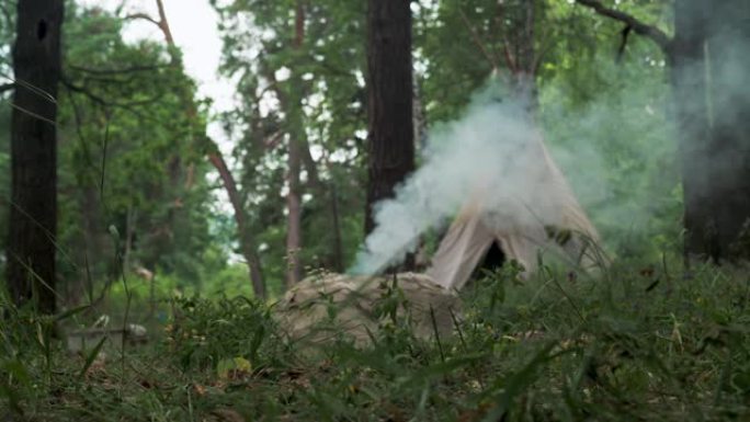 以古老的方式点燃北美印第安人陶瓷的篝火。在帐篷的背景下，印第安人的便携式住宅