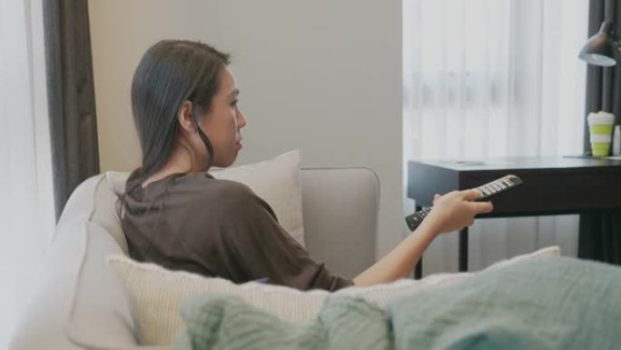 年轻女子在家看媒体电脑屏幕和电视