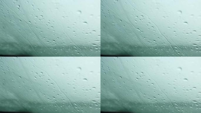 雨滴从汽车挡风玻璃上跑下来。恶劣的天气条件，秋天，能见度有限的条件。寒冷，潮湿，悲伤