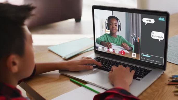 小学生在家中使用笔记本电脑进行在线课程，男孩在屏幕上聊天和网络聊天
