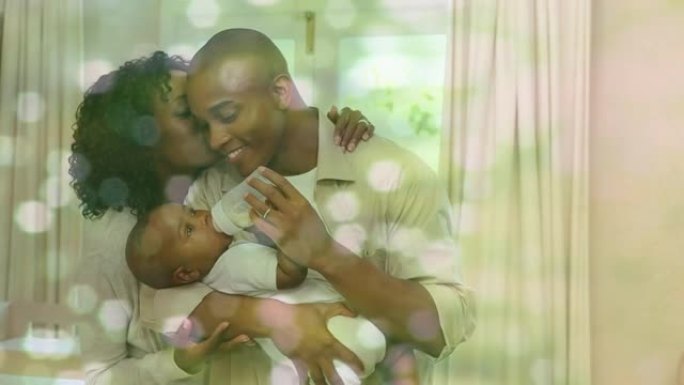 快乐的非洲裔美国父母在白色斑点上在家喂养婴儿的动画