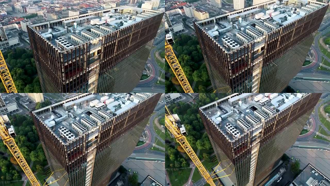 现代，在建的高层玻璃建筑，鸟瞰图。在欧洲城市建造商业摩天大楼。施工现场的高塔起重机。