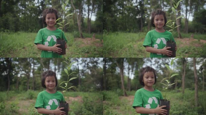 可爱的女孩站着拿着一棵植物，她准备在森林里种一棵树。