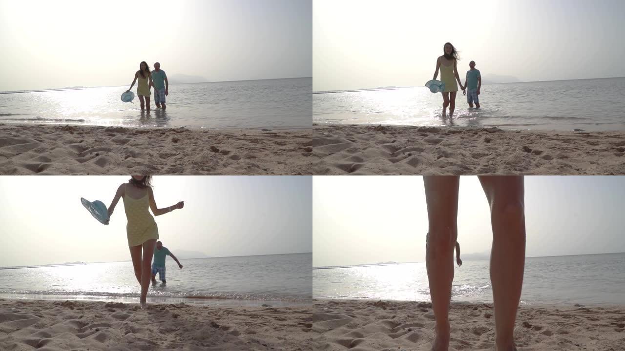 浪漫的情侣在海边日落牵着手在海滩上奔跑。爱与幸福的概念