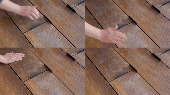 木匠在地板木板上设置甲板的间距。地板安装工作主建筑商建筑家居装修建筑木质甲板木板地板覆盖物。修理家庭