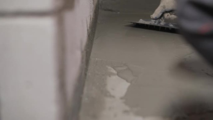 混凝土地板上的防水砂浆。工人用刷子对混凝土地板进行防水处理。混凝土地板维修