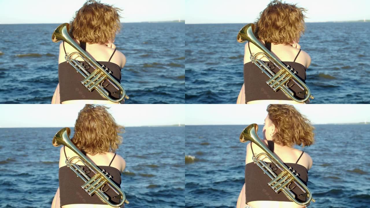 一个女人坐在海上等待奇迹，在乐器后面