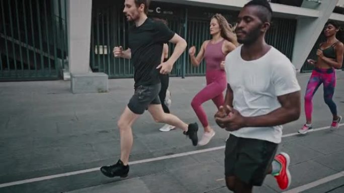 黑人和他的运动员团队在体育场内奔跑。非裔美国人和他的志同道合的朋友穿着便携式制服进行了集体跑步训练