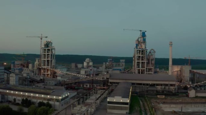 日落时工业生产区高工厂结构的水泥厂。空中无人机视图