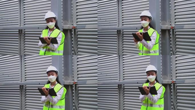 工程师正在检查工业冷却塔空调是大型工业建筑的水冷却塔空气冷水机组，以控制空气系统，戴着口罩以保护污染