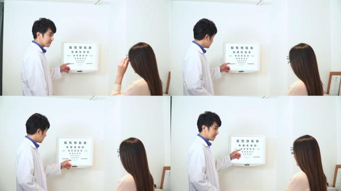 验光师办公室，男人在视力表上指出，Snellen图表，亚洲年轻女子戴着可调节的瞳孔间距离试验框架，以