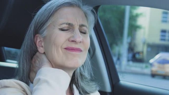 疲惫的过度劳累的女人触摸痛苦的脖子解开安全带坐在车里