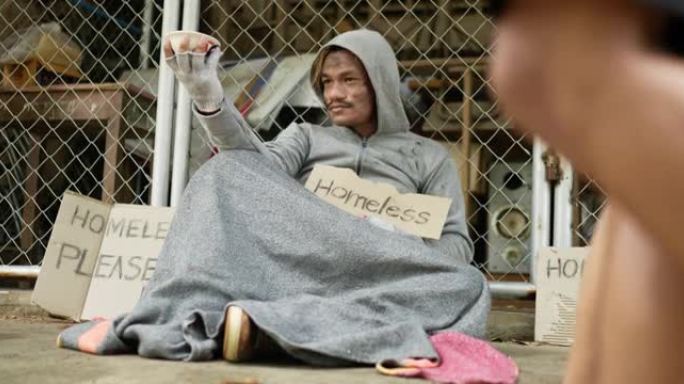 无家可归者坐在地板上的特写镜头。