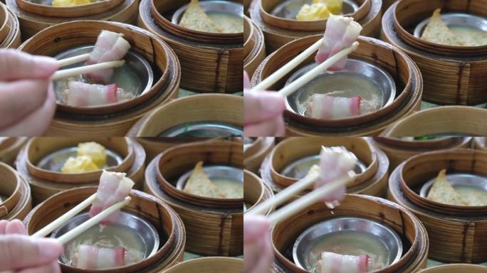用筷子在餐厅用竹篮里用手吃传统的中国食物新鲜美味可口的蒸肉点心