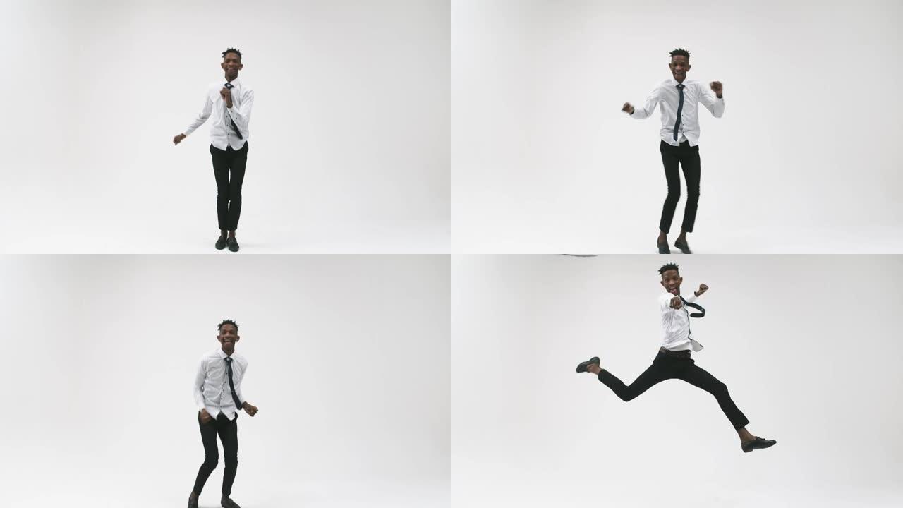 情绪自信的黑人男子穿着白衬衫和领带在工作室的白色背景上跳舞和跳高