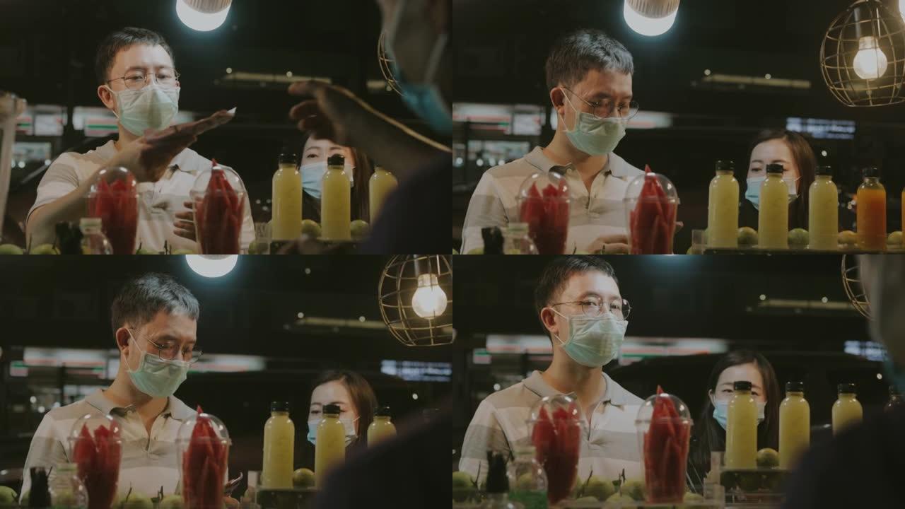 泰国积极男子在街头夜市的果汁吧用现金支付果汁，并与姐妹股票视频。