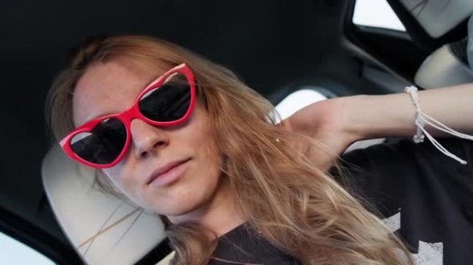 年轻女子公路旅行时在车里自拍视频。