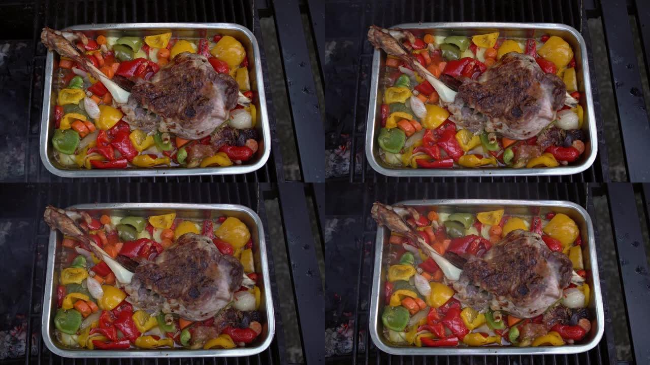 烤羊肉腿，配上辣椒和土豆，放在金属盘里