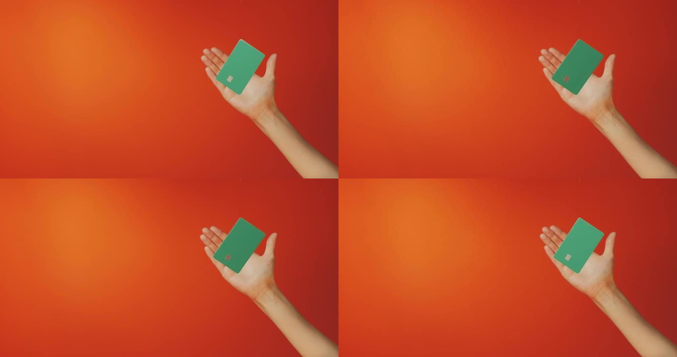 女性手和悬浮模板模拟银行信用卡在线服务孤立在橙色背景