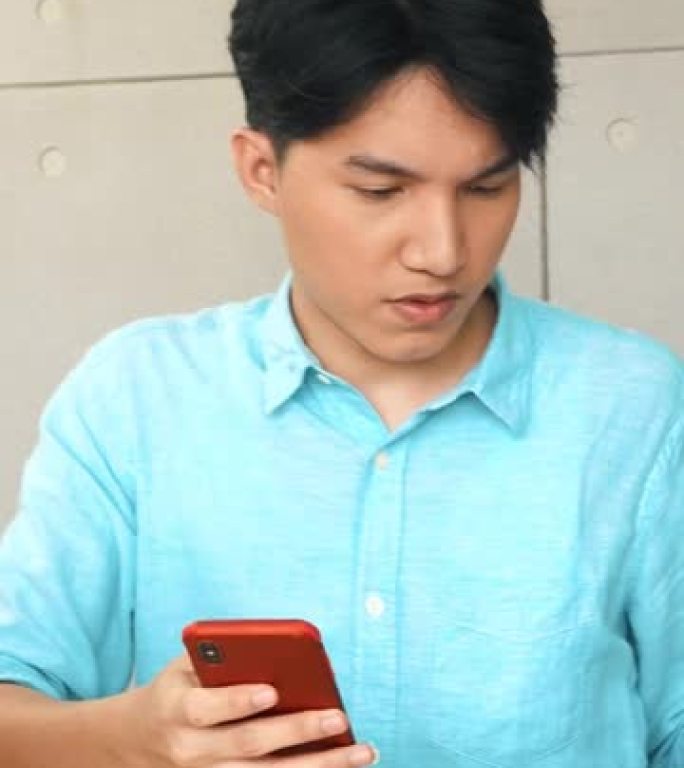亚洲年轻商人在办公室为智能手机发短信工作