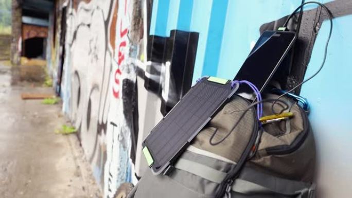 可再生能源的概念。平板电脑由背包上的便携式太阳能电池板电池充电。