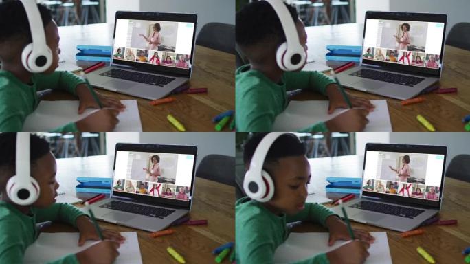 非裔美国男孩在家里用笔记本电脑进行视频会议时做作业