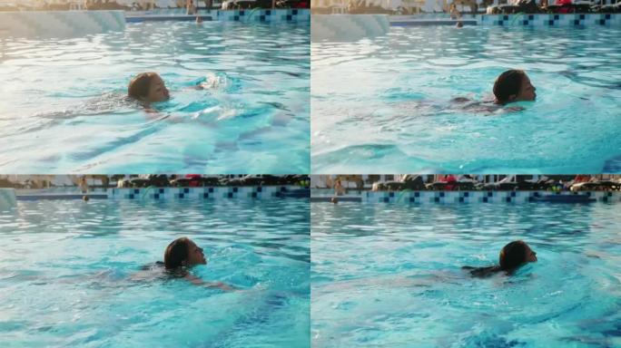 十几岁的女孩在度假酒店的室外游泳池游泳