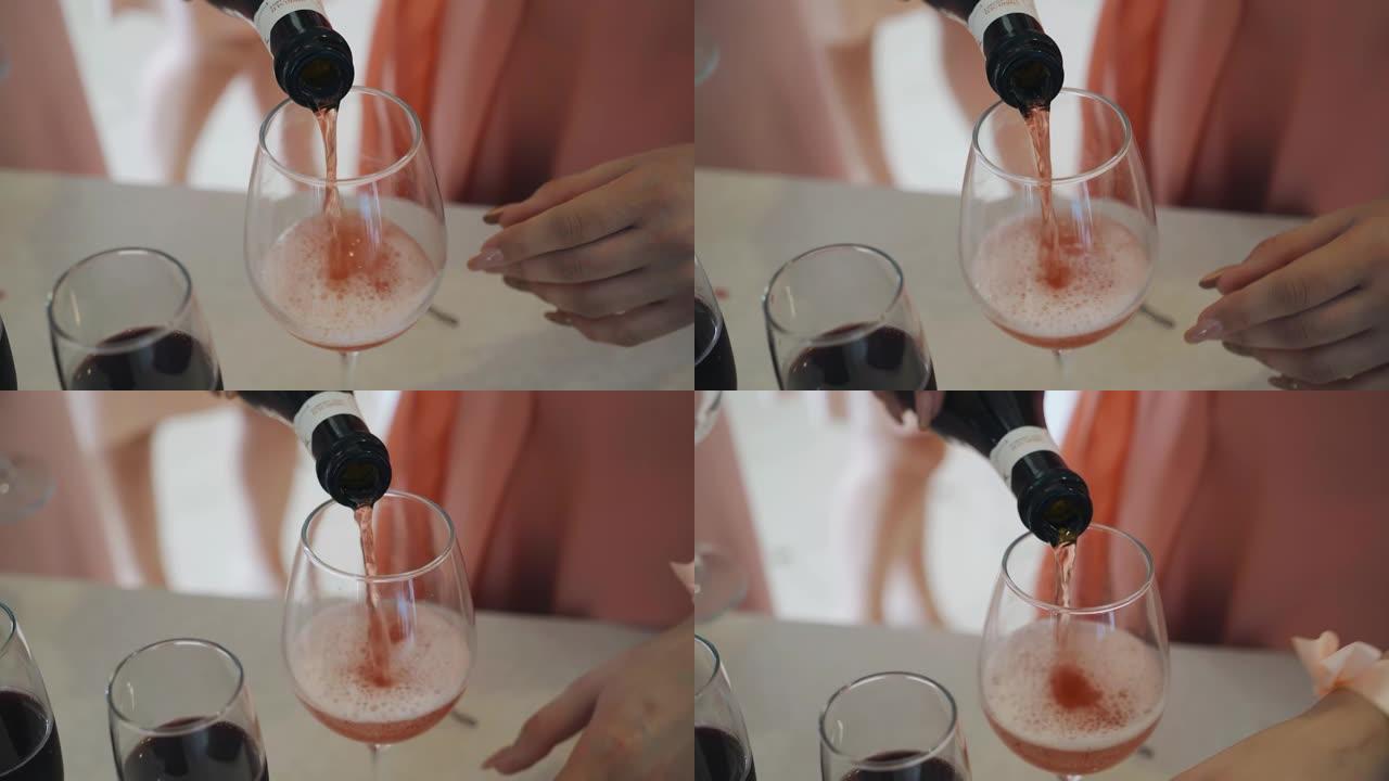女孩把红酒从瓶子里倒进玻璃杯里。特写拍摄