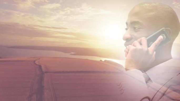 在日落景观上使用智能手机微笑的非洲裔美国人的动画