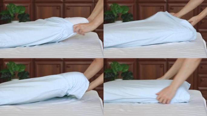女性双手做床单，换枕套。家务和家政或酒店服务的概念