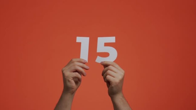 十五号在手。显示数字的人，15个由雕刻纸制成的数字，用于投票或数学学习