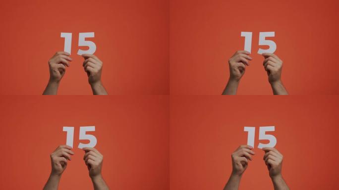 十五号在手。显示数字的人，15个由雕刻纸制成的数字，用于投票或数学学习