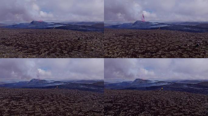 广阔的空旷地带，冒险家观看着蓬松的云喷发的火山